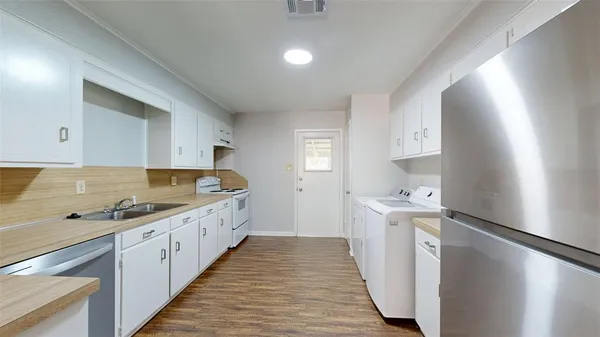 a large kitchen with stainless steel appliances a sink and cabinets