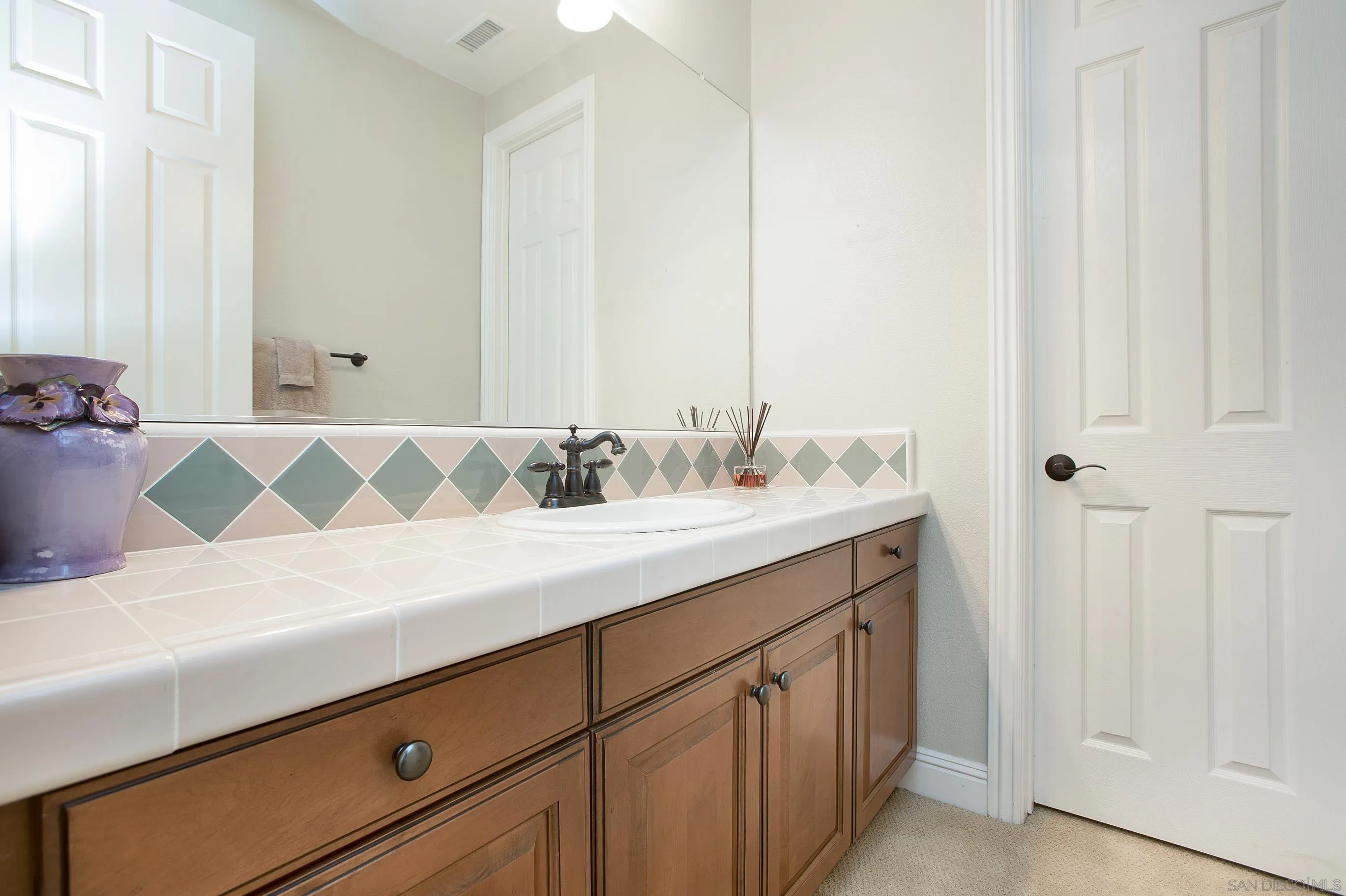 562 Shasta Drive Encinitas, CA 92024 - Photo 45 of 59 a bathroom with a sink and a mirror