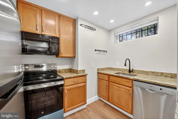 a kitchen with stainless steel appliances a stove sink microwave and cabinets