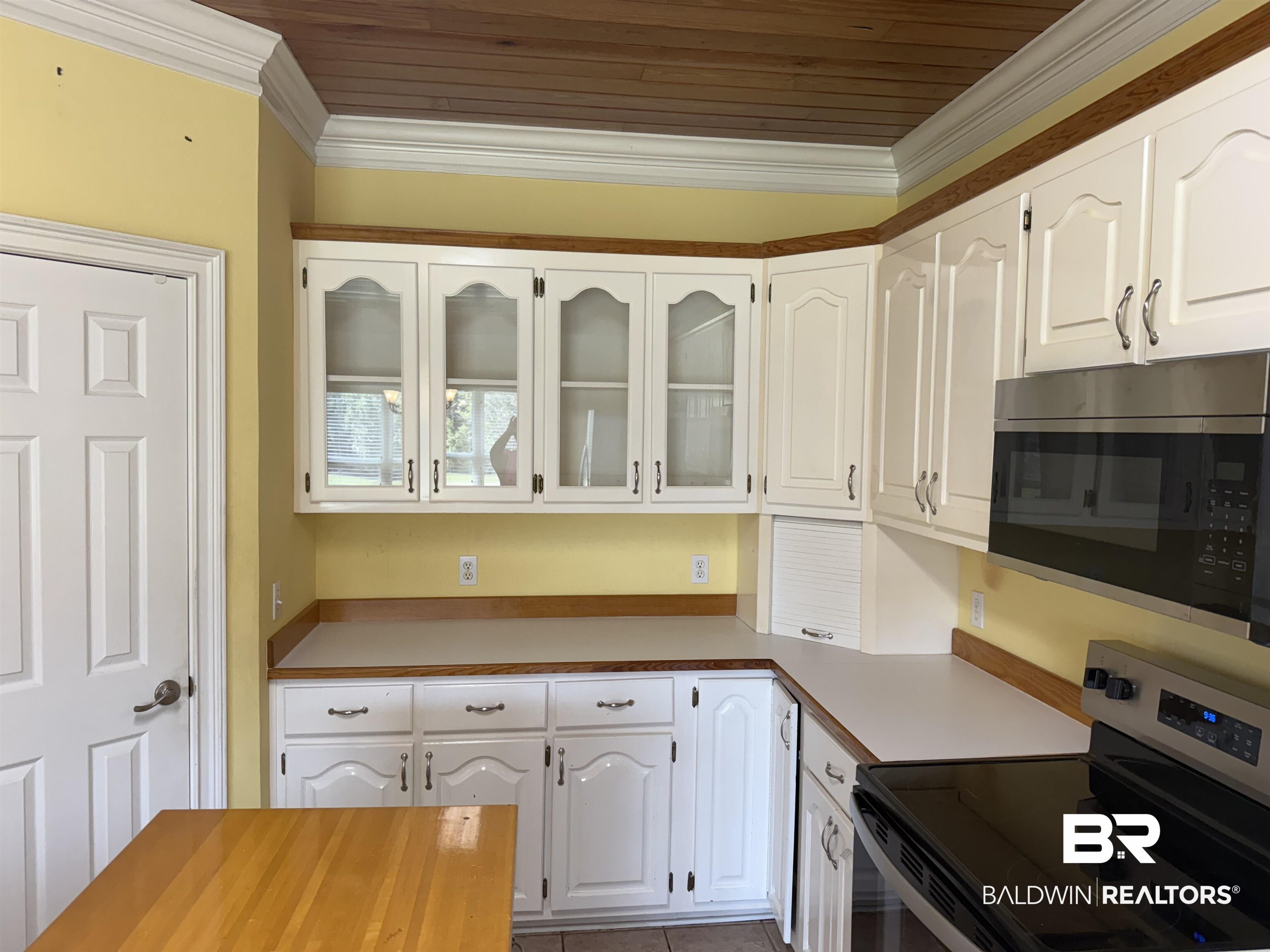 415 Juniper Creek Road Brewton, AL 36426 - Photo 8 of 35 Kitchen featuring glass insert cabinets, appliances with stainless steel finishes, white cabinetry, ornamental molding, and tile patterned flooring