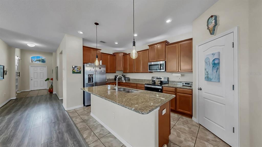 2408 Nighthawk Landing Court Ruskin, FL 33570 - Photo 11 of 50 a kitchen with a center island wooden floor and stainless steel appliances