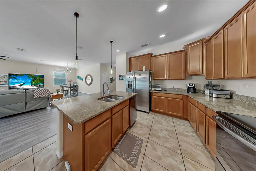 2408 Nighthawk Landing Court Ruskin, FL 33570 - Photo 12 of 50 a kitchen with stainless steel appliances granite countertop a sink counter space cabinets and a stove