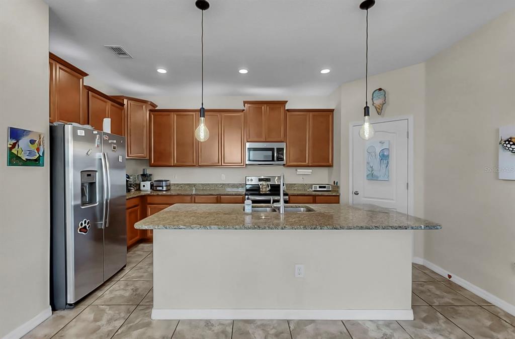 2408 Nighthawk Landing Court Ruskin, FL 33570 - Photo 13 of 50 a kitchen with stainless steel appliances granite countertop a refrigerator a sink a stove and a granite counter tops