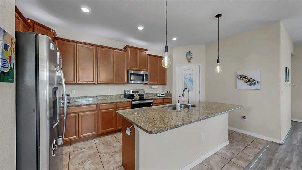 2408 Nighthawk Landing Court Ruskin, FL 33570 - Photo 14 of 50 a kitchen with stainless steel appliances granite countertop a sink refrigerator and cabinets