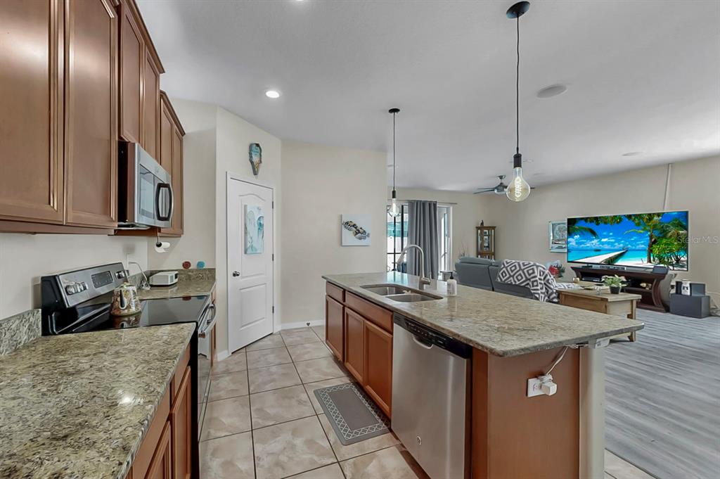2408 Nighthawk Landing Court Ruskin, FL 33570 - Photo 15 of 50 a kitchen with stainless steel appliances granite countertop a sink a stove and a refrigerator