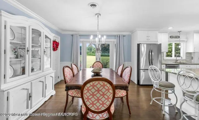 a dining room with furniture a chandelier and wooden floor