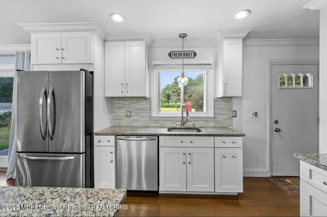 a kitchen with stainless steel appliances a refrigerator sink and cabinets