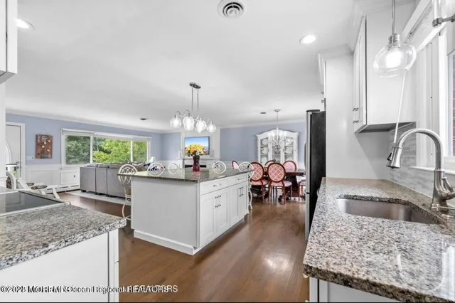 a kitchen with sink a counter and chairs