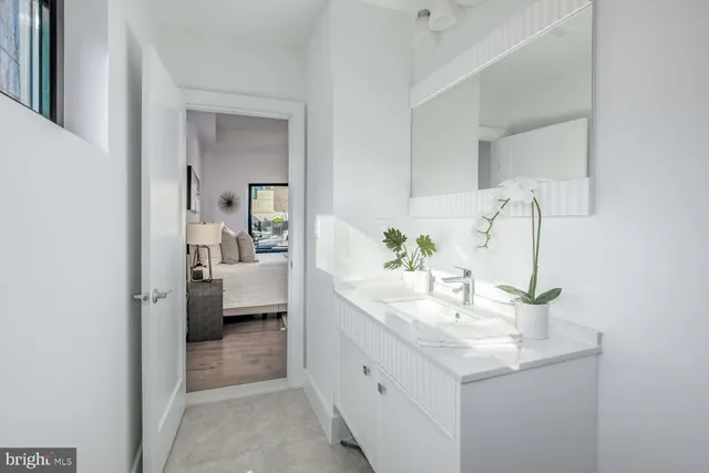 a en suite bathroom with a granite countertop sink and a mirror