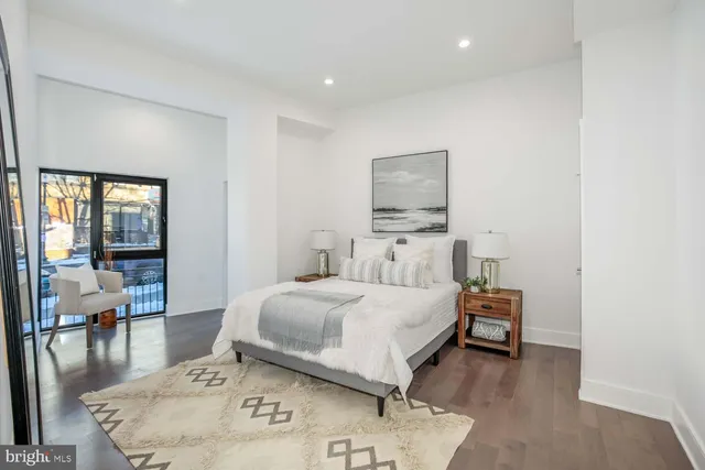 a bedroom with a bed and large windows