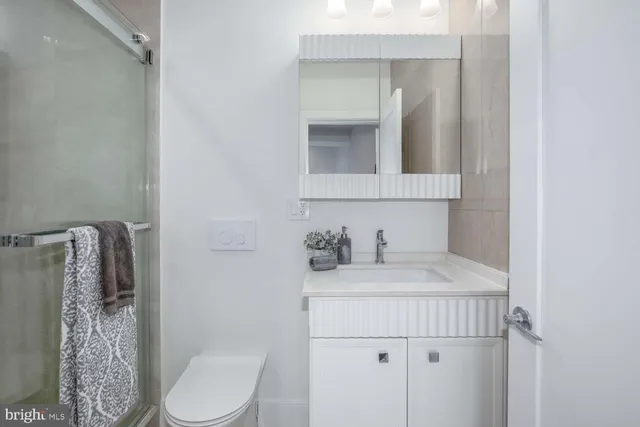 a bathroom with a sink vanity mirror and toilet