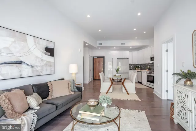 a living room with furniture kitchen and a table