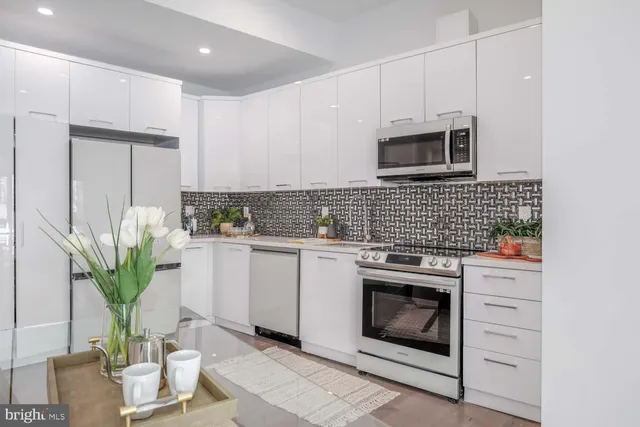 a kitchen with stainless steel appliances kitchen island granite countertop a stove a sink and a microwave