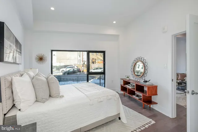 a bedroom with a bed a chandelier and a window