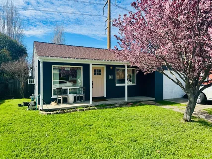 a view of a house with a yard and sitting area
