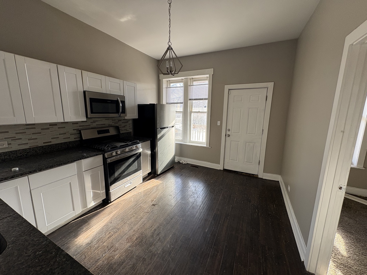 3843 West Fillmore Street Chicago, IL 60624 - Photo 22 of 38 a kitchen with granite countertop a stove top oven a sink dishwasher a refrigerator and a microwave