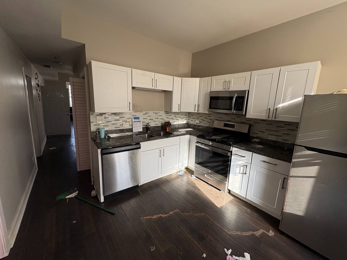 3843 West Fillmore Street Chicago, IL 60624 - Photo 3 of 38 a kitchen with granite countertop a refrigerator stove and microwave