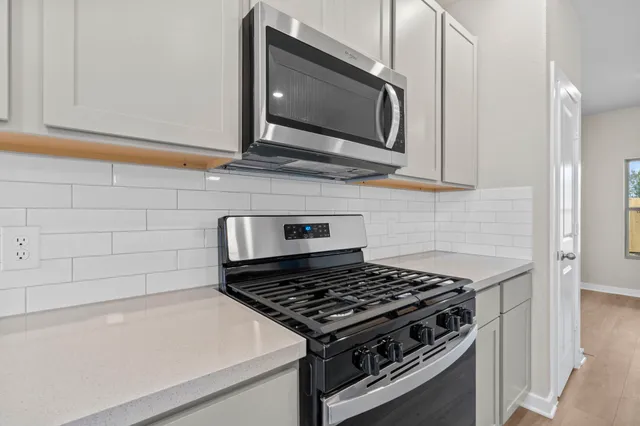 a stove top oven sitting inside of a kitchen