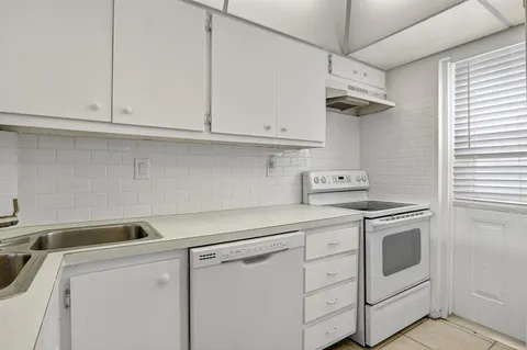 a kitchen with white cabinets and white appliances