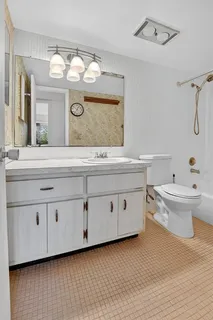 a bathroom with a double vanity sink mirror and toilet