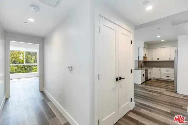 a view of a hallway with wooden floor and staircase