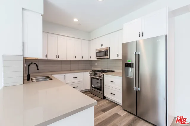 a kitchen with a refrigerator sink and stove