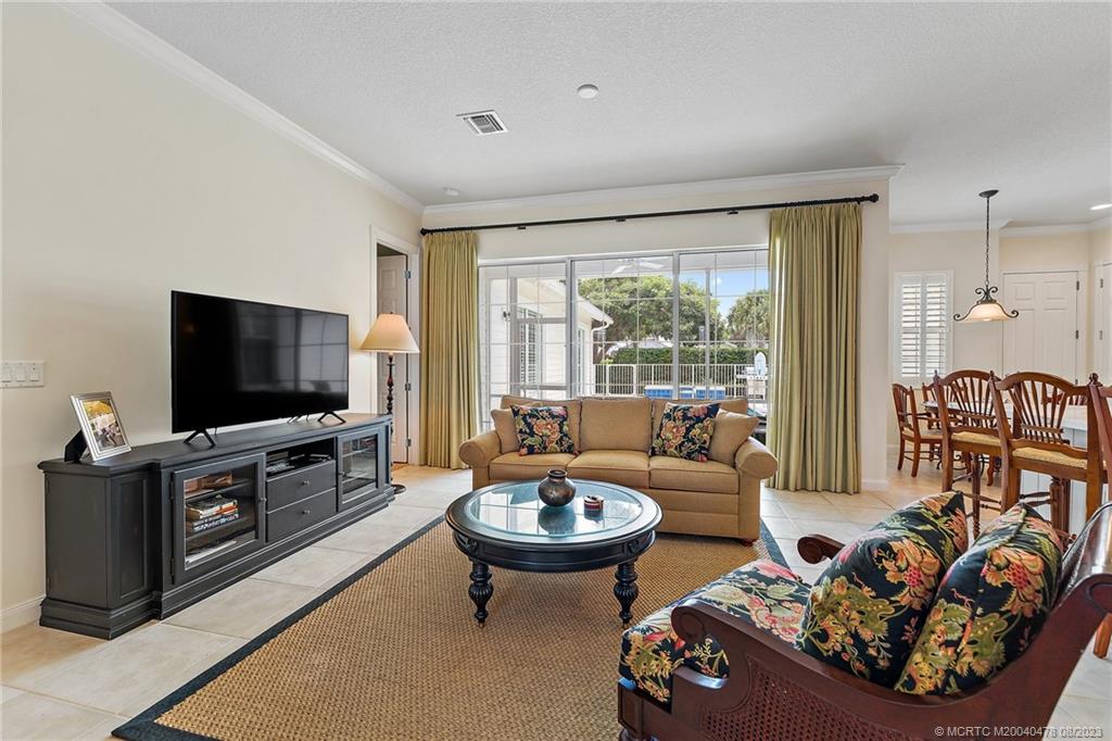 1162 Tropical Drive Jupiter, FL 33458 - Photo 11 of 43 a living room with furniture a flat screen tv and a large window