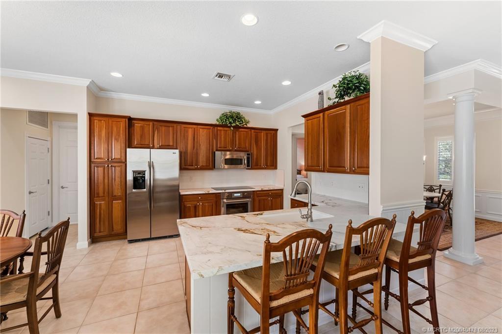 1162 Tropical Drive Jupiter, FL 33458 - Photo 13 of 43 a kitchen with stainless steel appliances granite countertop a table and chairs