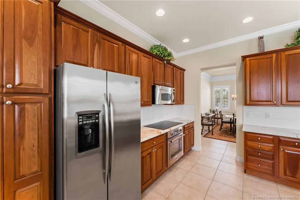 1162 Tropical Drive Jupiter, FL 33458 - Photo 14 of 43 a kitchen with stainless steel appliances granite countertop a refrigerator and a stove top oven
