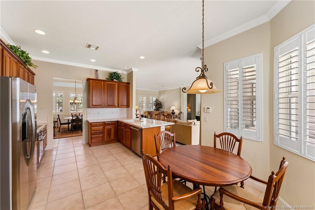 1162 Tropical Drive Jupiter, FL 33458 - Photo 17 of 43 a kitchen with stainless steel appliances granite countertop a stove a sink dishwasher a dining table and chairs