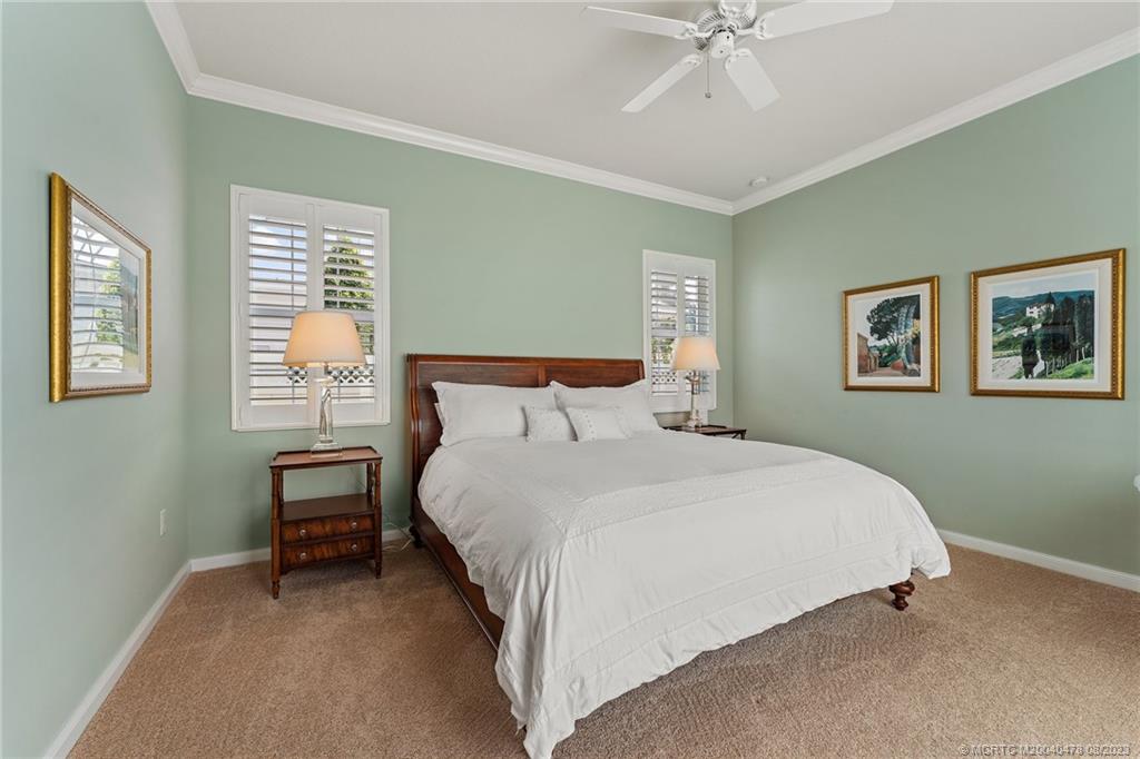 1162 Tropical Drive Jupiter, FL 33458 - Photo 19 of 43 a bedroom with a bed and a chandelier