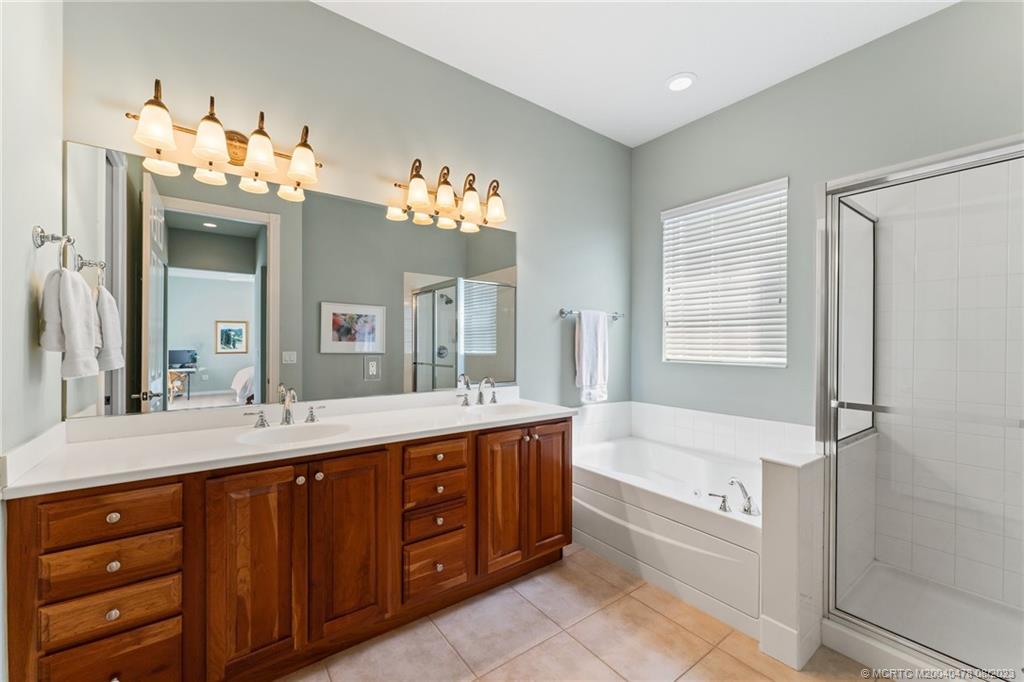1162 Tropical Drive Jupiter, FL 33458 - Photo 21 of 43 a spacious bathroom with a tub sink and mirror