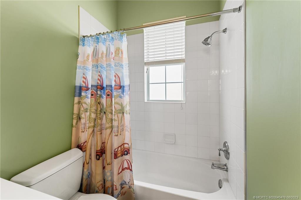 1162 Tropical Drive Jupiter, FL 33458 - Photo 27 of 43 a bathroom with a shower curtain and a bathtub