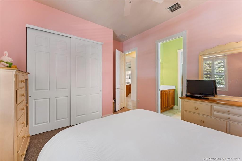 1162 Tropical Drive Jupiter, FL 33458 - Photo 28 of 43 a bedroom with a bed and a flat screen tv