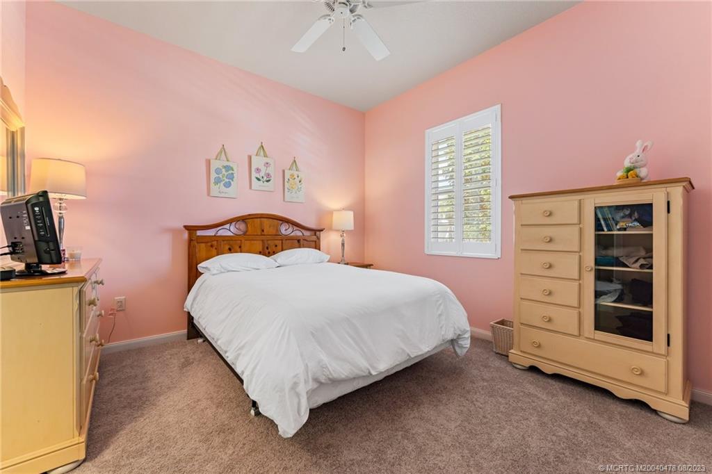 1162 Tropical Drive Jupiter, FL 33458 - Photo 29 of 43 a bedroom with a bed and a chandelier