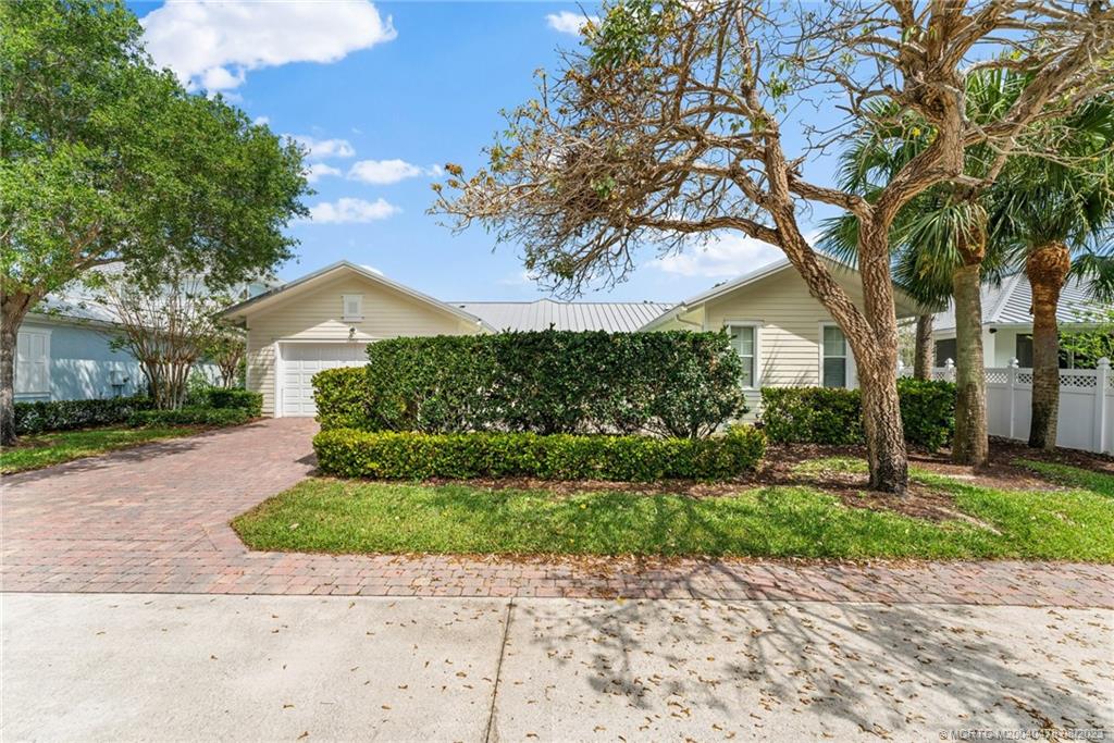 1162 Tropical Drive Jupiter, FL 33458 - Photo 36 of 43 a front view of a house with a yard and a garage