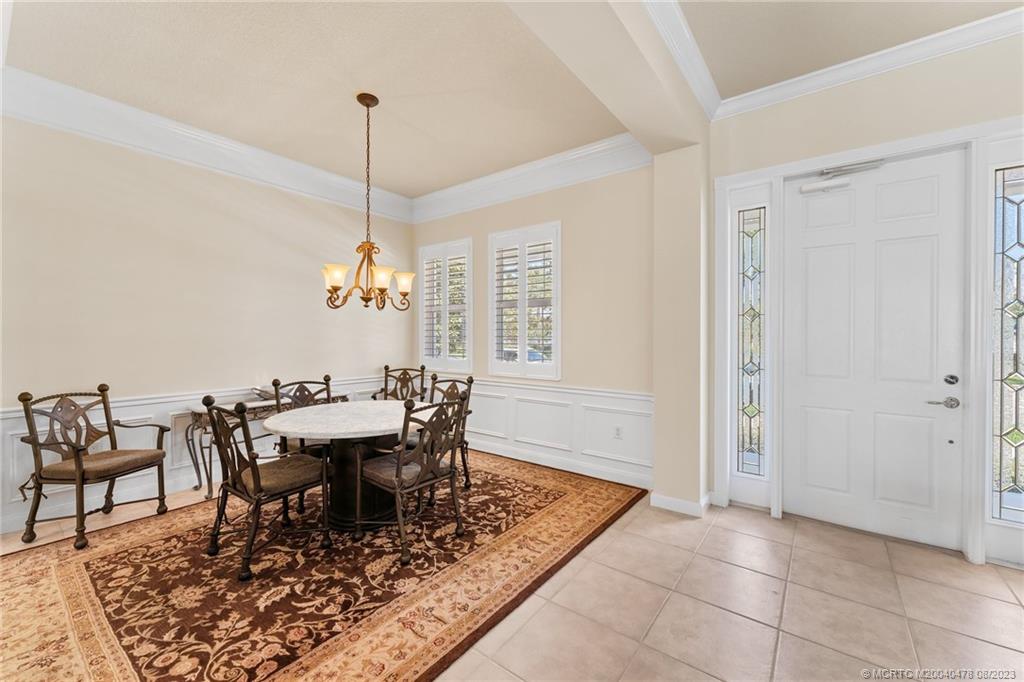 1162 Tropical Drive Jupiter, FL 33458 - Photo 9 of 43 a dining room with furniture a rug and a chandelier