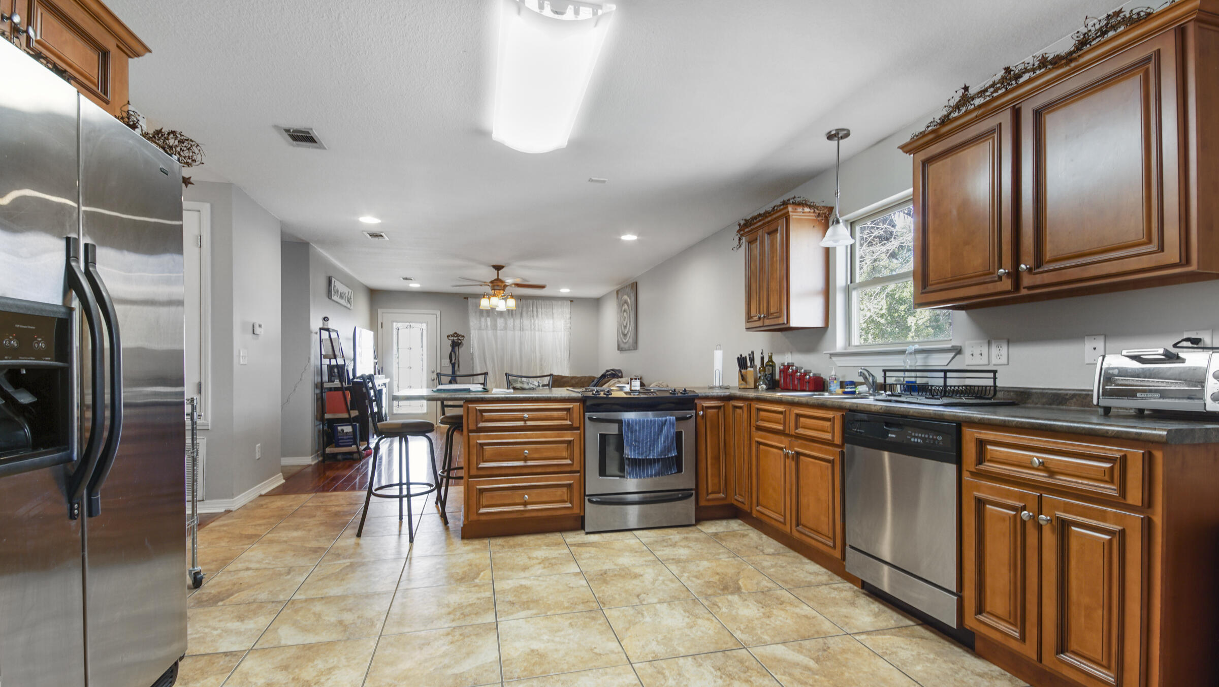 908 Valley Road Crestview, FL 32539 - Photo 13 of 22 a large kitchen with stainless steel appliances granite countertop a large stove top oven a refrigerator and a sink