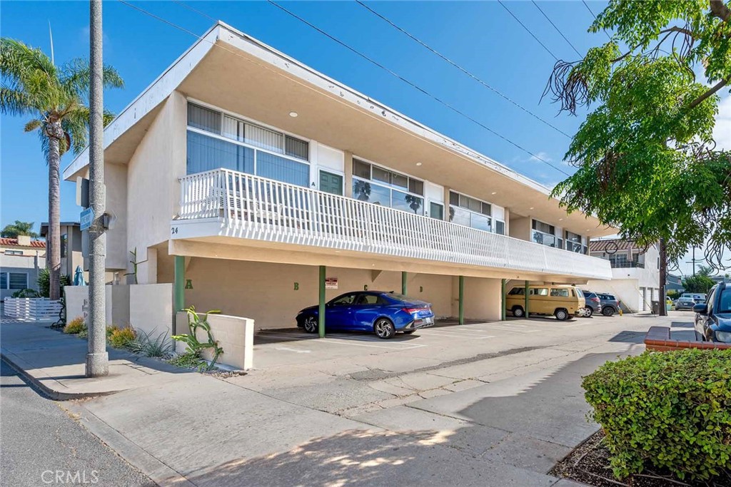 a front view of a building with cars parked