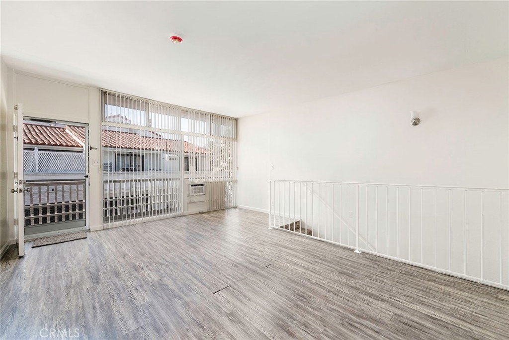 24 Roswell Avenue Long Beach, CA 90803 - Photo 7 of 13 an empty room with wooden floor and windows