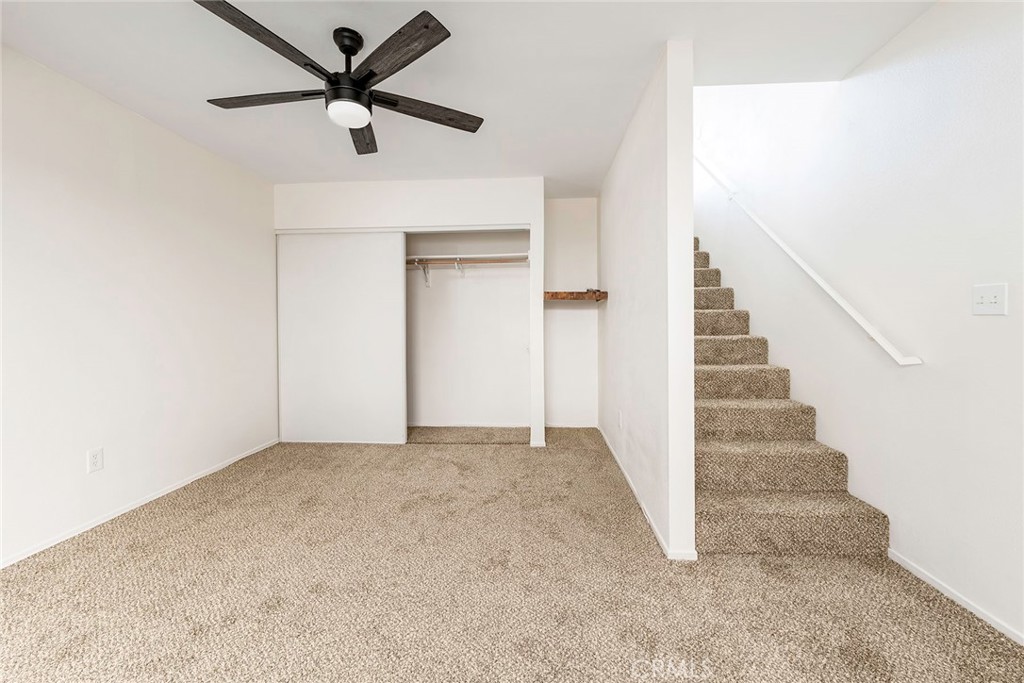 24 Roswell Avenue Long Beach, CA 90803 - Photo 10 of 13 an empty room with a ceiling fan and stairs