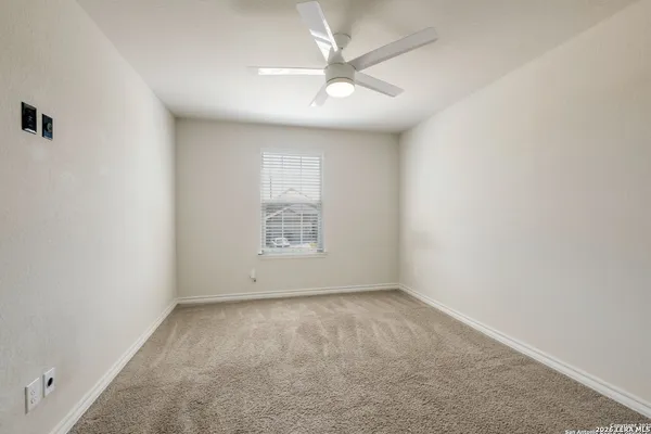 an empty room with a window and a fan
