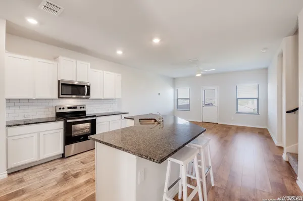 a kitchen with granite countertop stainless steel appliances and wooden cabinets