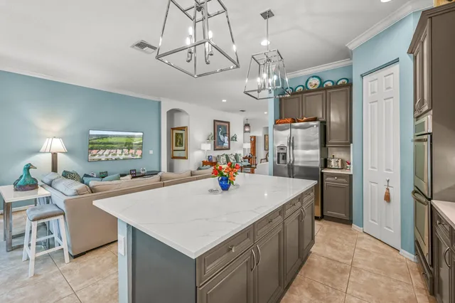 a kitchen with a refrigerator a sink dishwasher a dining table and chairs with wooden floor