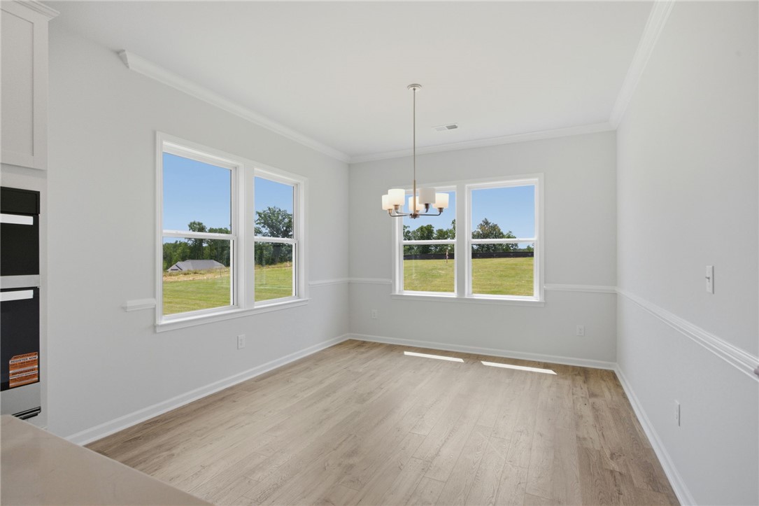 557 Hydrangea Street, Unit LOT 46 Seneca, SC 29678 - Photo 8 of 37 A well-lit interior space with light-toned flooring offers serene views of the surrounding landscape.
