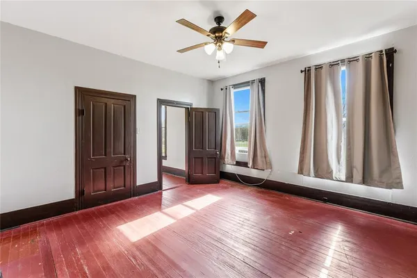 an empty room with wooden floor and a window