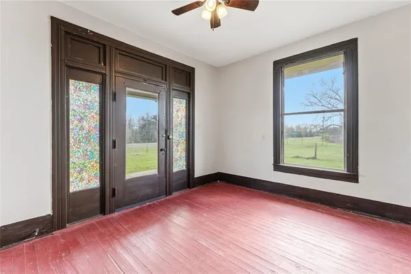 a view of a room with window a ceiling fan and wooden floor