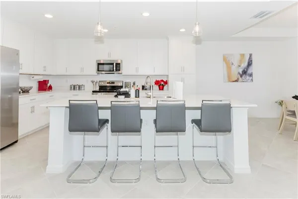 a room with stainless steel appliances kitchen island furniture and white cabinets