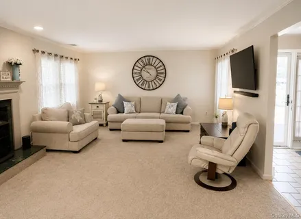 a living room with furniture a flat screen tv and a window