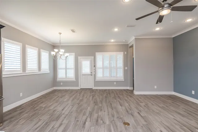 a view of an empty room with a window and wooden floor